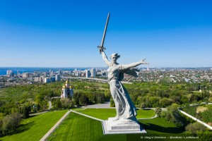 Вид с квадрокоптера на монумент «Родина-мать» на фоне центра Волгограда.